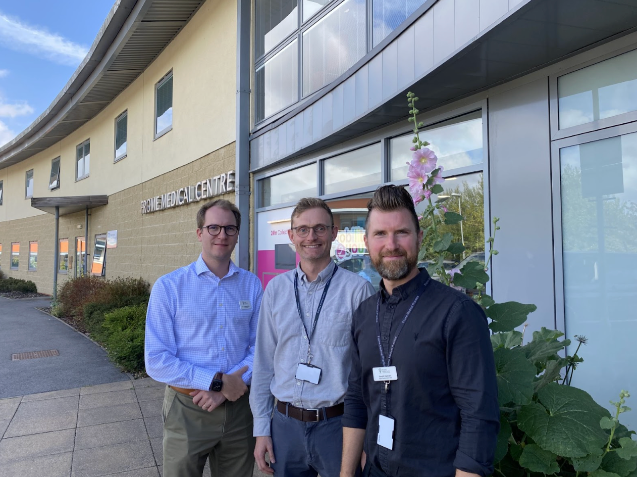 Three men stand outside the Frome Medical Centre.