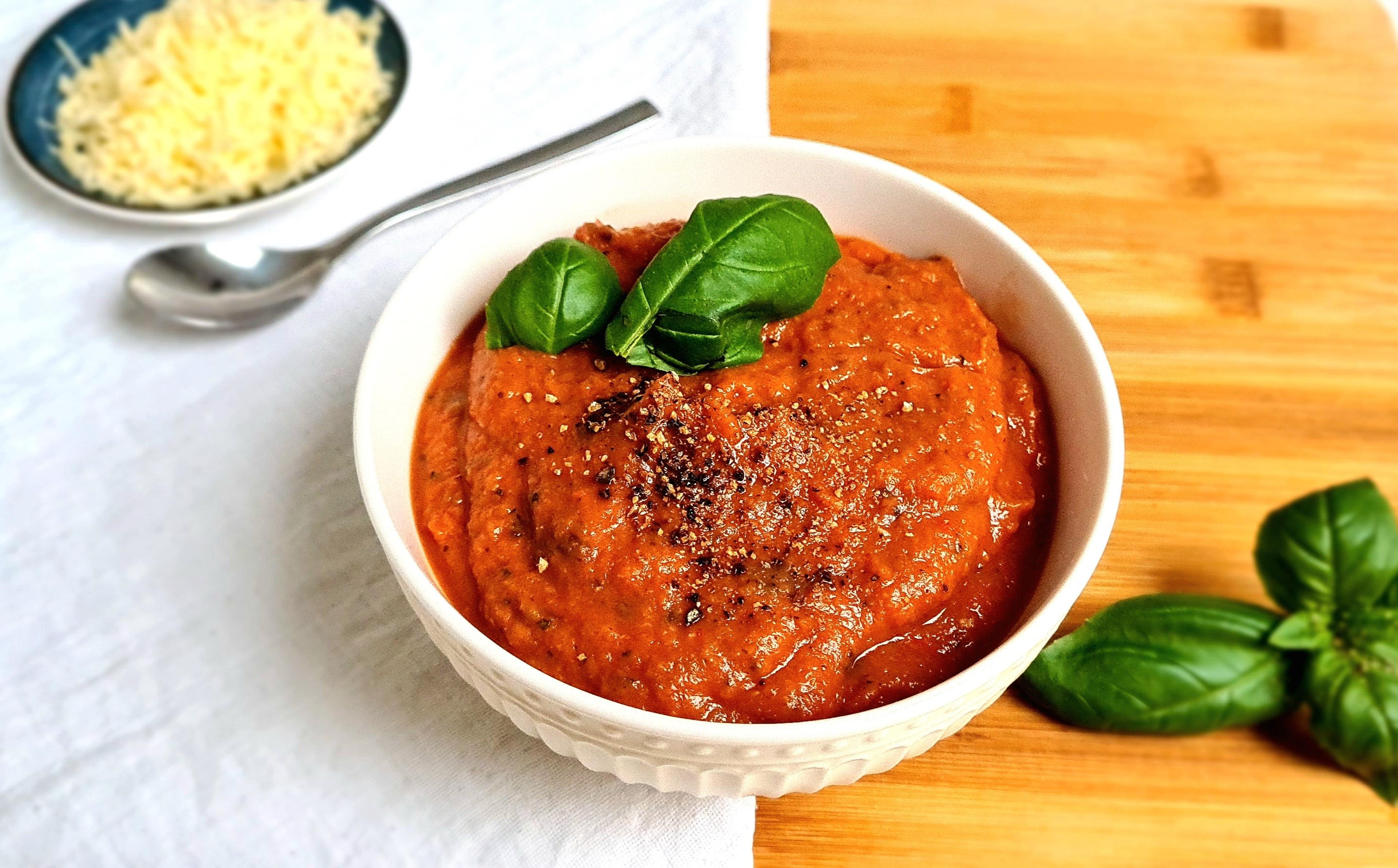 Zelfgemaakte rode pastasaus met basilicum in een kom.
