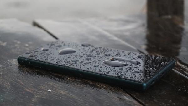 black smartphone on top of brown wooden surface