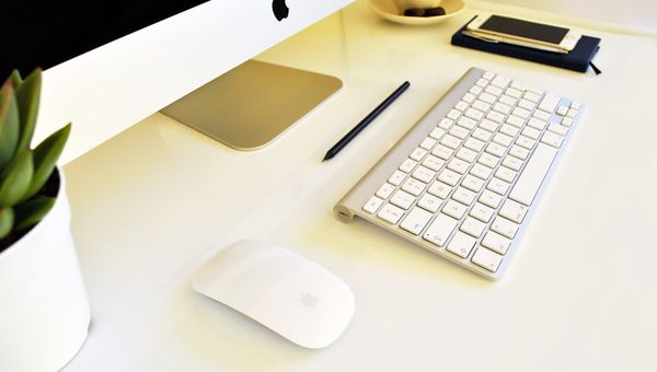 a computer keyboard and mouse on a desk