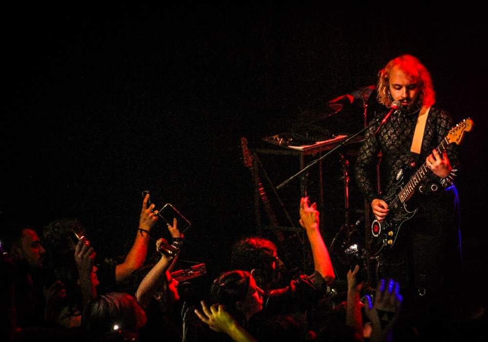 Mika play guitar in front of an cheering crowd