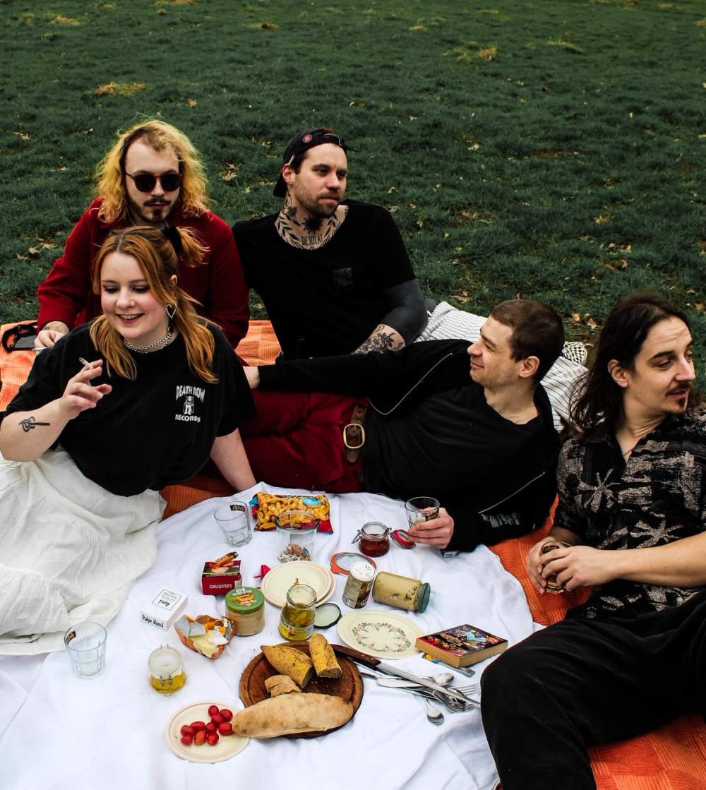 Five band members of Desolat having a picnic in the park