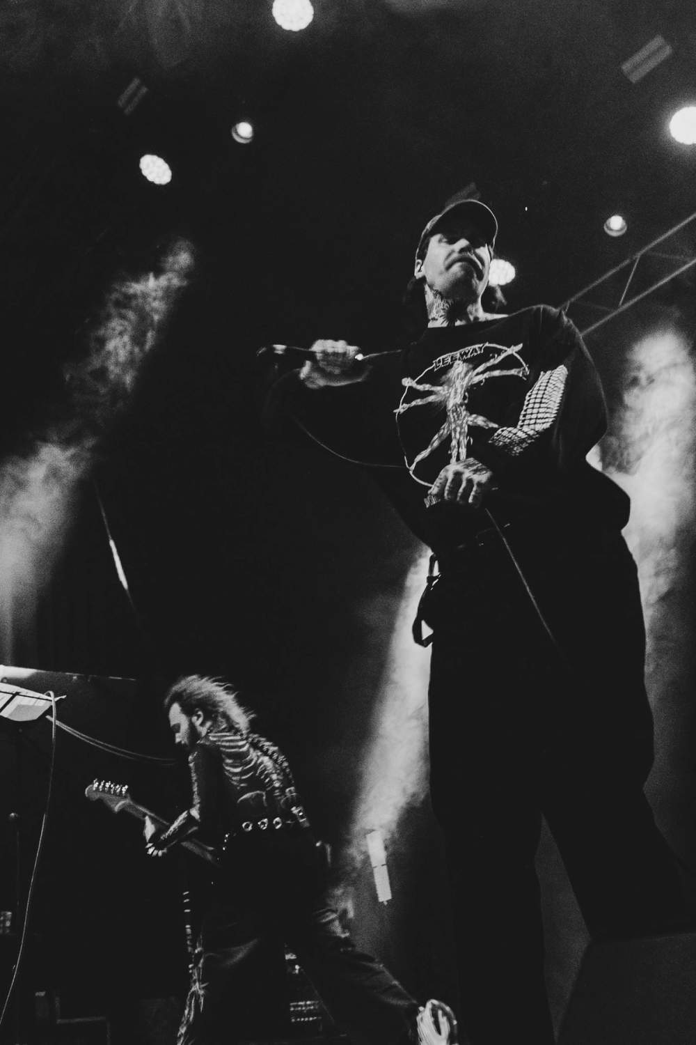 Markus is dancing in the foreground, while Mika is headbanging while playing guitar in the background