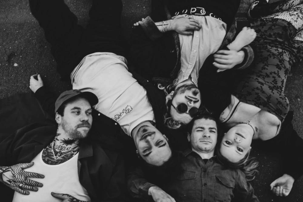 Whole band laying on the ground watching the skies