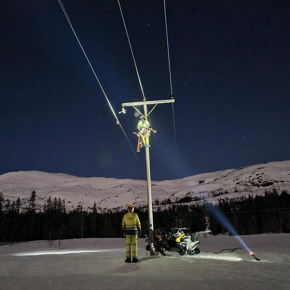 Feilretting i stolpe: Et bilde av en stolpe om natten, omgitt av naturlig landskap og belysning.