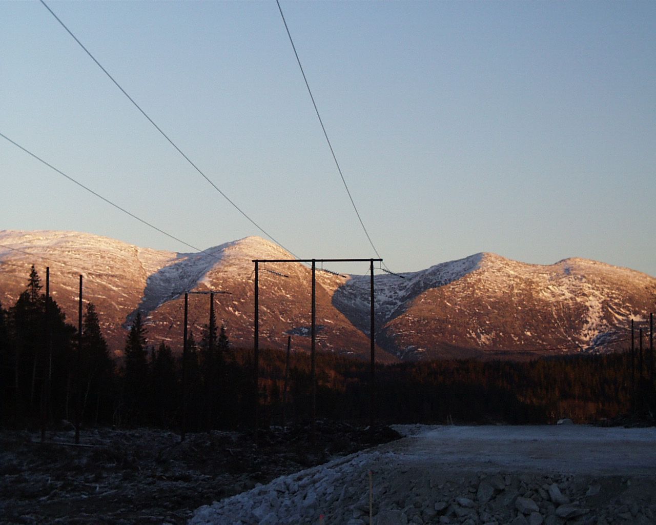 Strømlinje på fjell, med blå himmel og litt snø.