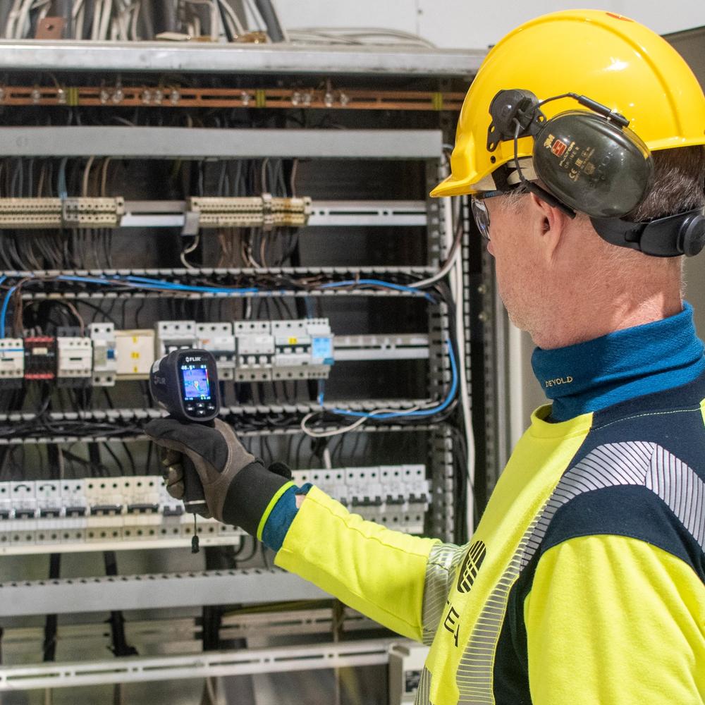 Montør som måler i sikringsskap.