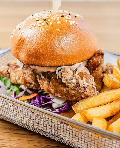Karaage chicken in an artisan bread roll with pickles and yuzu mayo
