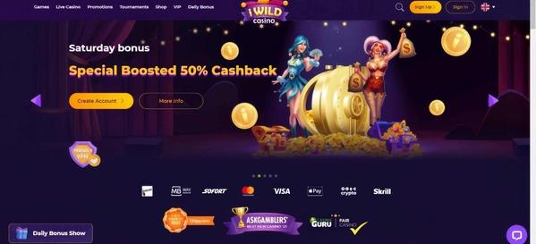 iWild Casino homepage displaying 50% cashback Saturday bonus promotion with golden pumpkin carriage, payment methods including Visa, Skrill, and cryptocurrency options available