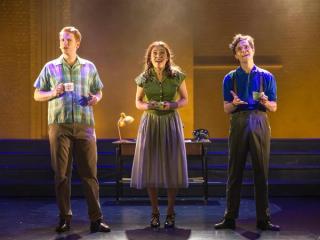 Ryan 在舞臺上與兩位表演者一起唱歌。