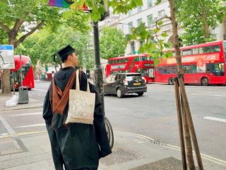 一位畢業於皇家音樂學院的學生,站在倫敦的街道上。