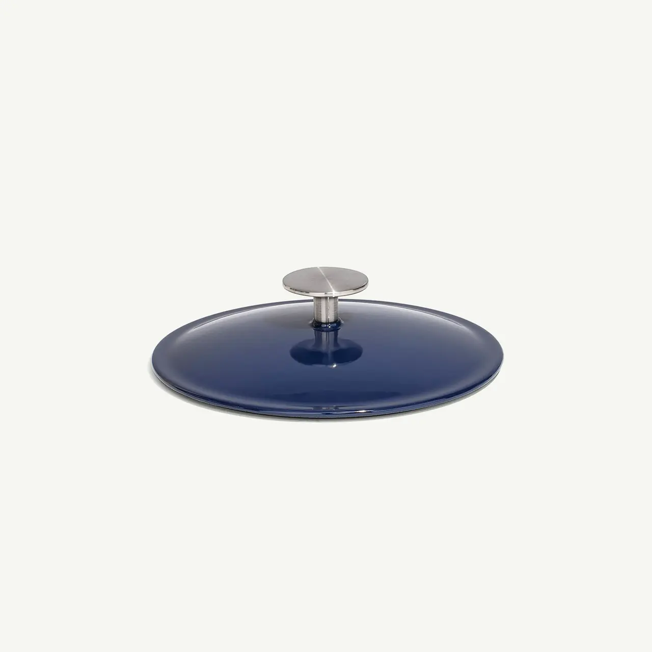 A blue, round lid with a silver knob on top isolated on a white background.