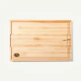 A wooden cutting board with a smooth surface and a logo in the bottom corner.