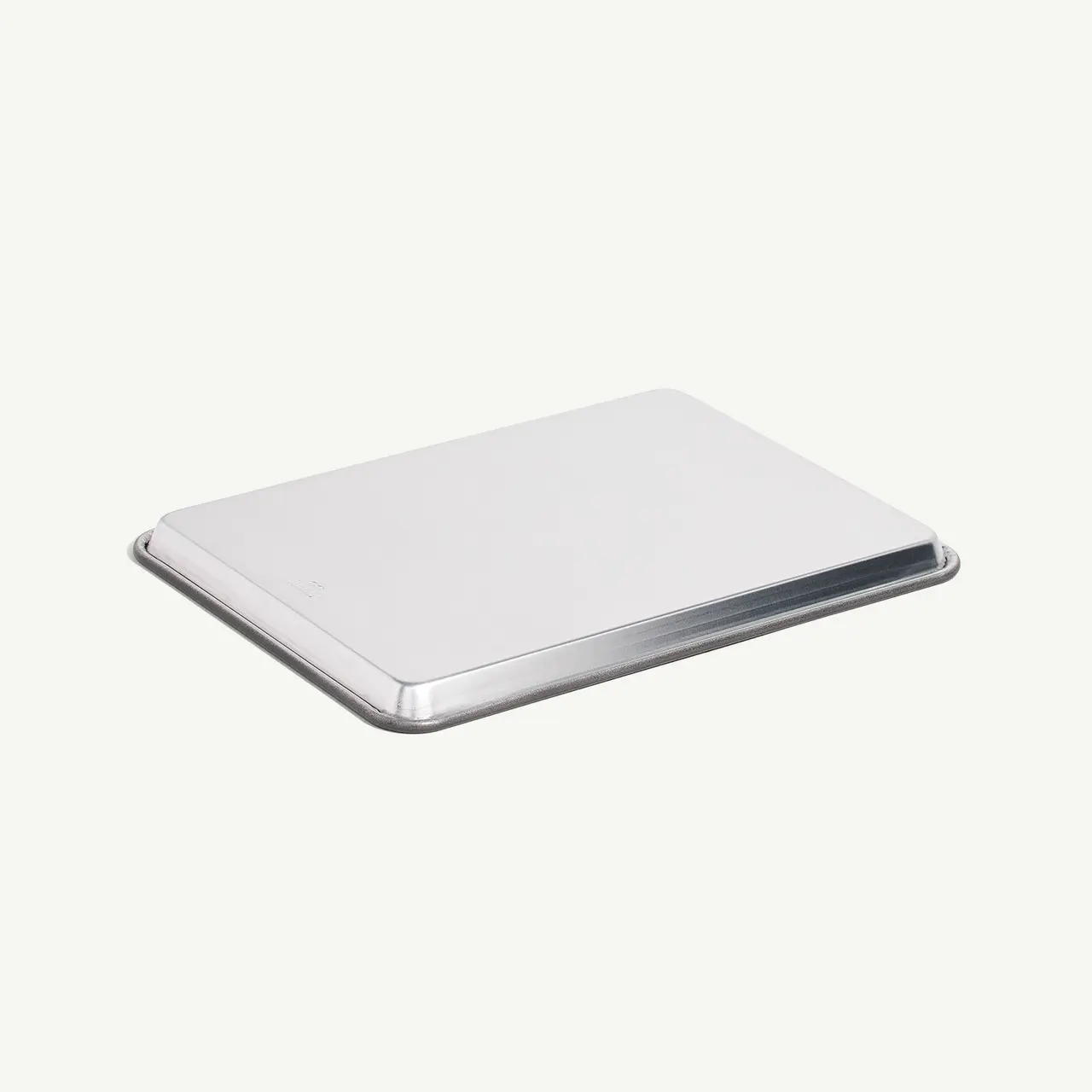 A closed silver laptop is positioned on a plain background.
