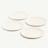 Four white plain plates are arranged on a light background.