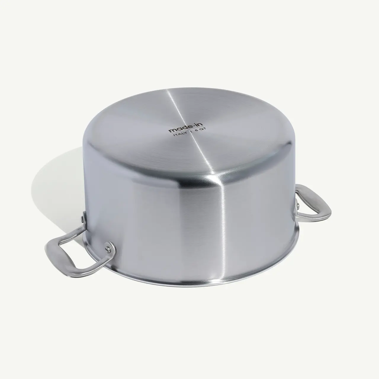 A stainless steel pot with two handles against a plain background.