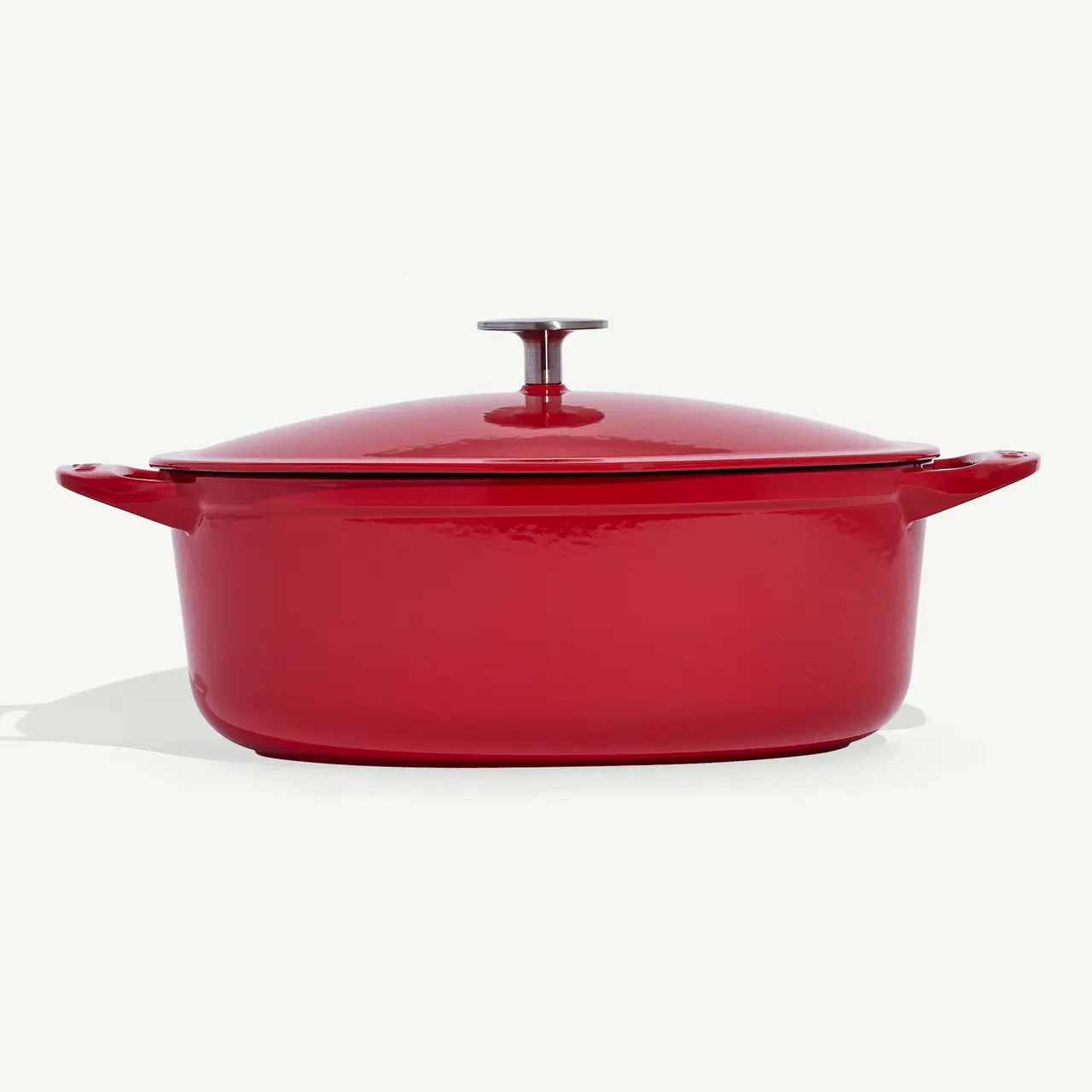 A red enameled cast iron Dutch oven with a lid on a white background.