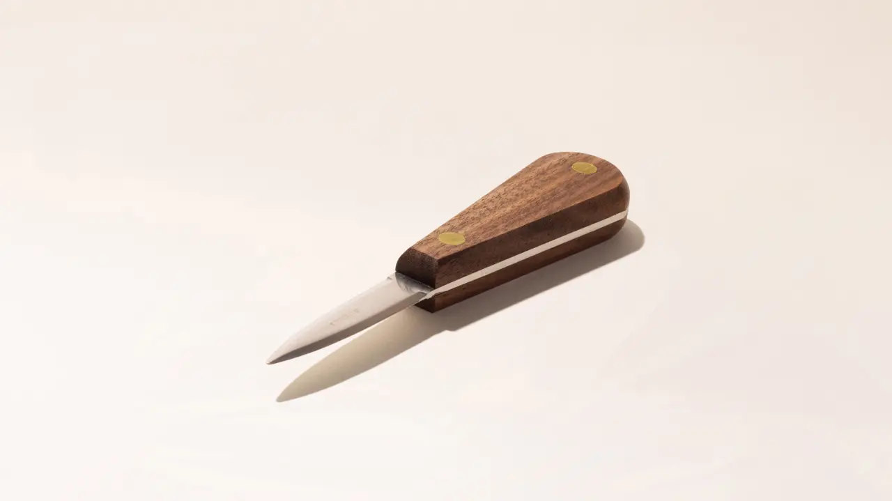 A simple wooden-handled utility knife with a short blade on a light background.