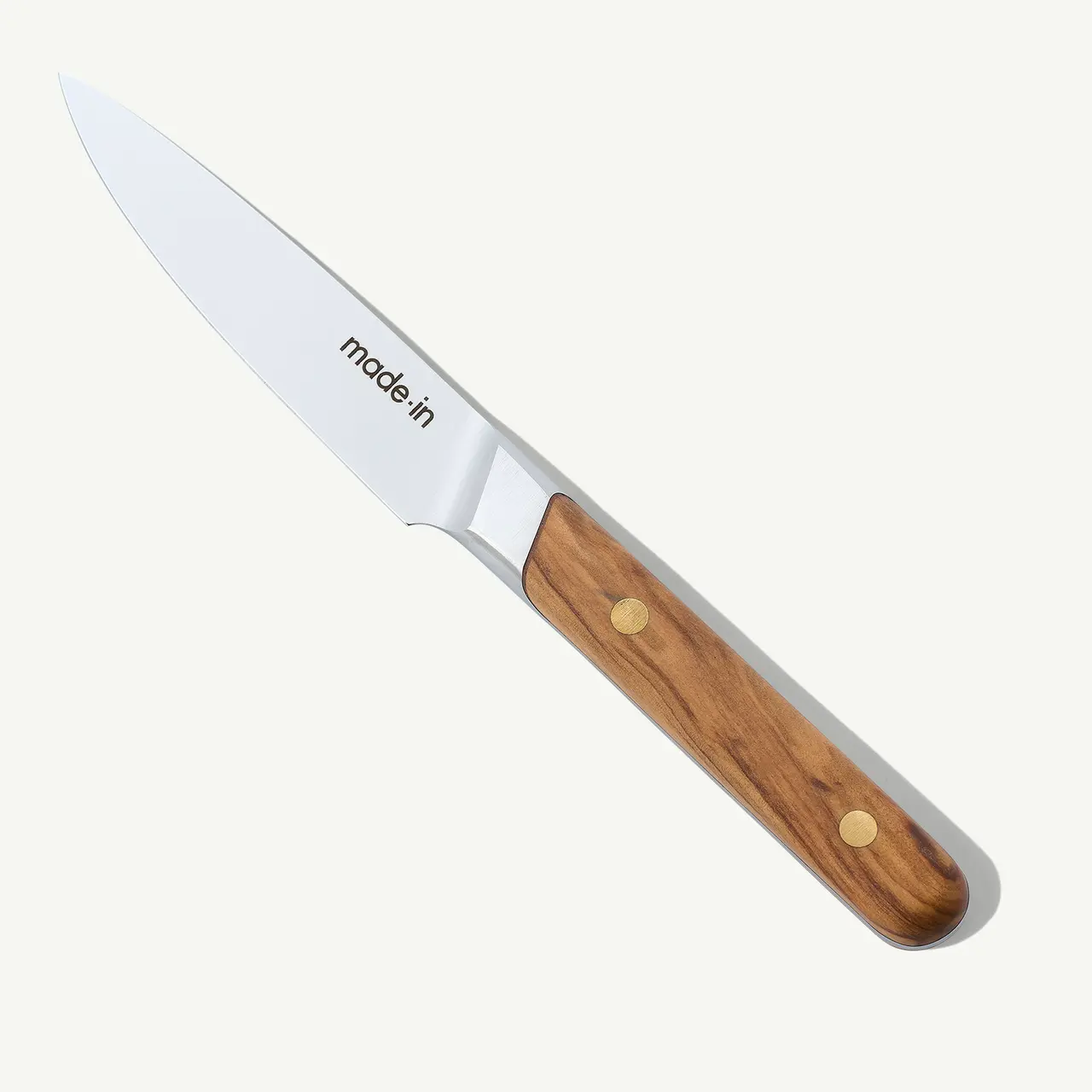A stainless steel chef's knife with a wooden handle and the text "made in" on the blade, isolated on a white background.