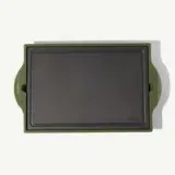 A rectangular non-stick griddle with green handles on either side.