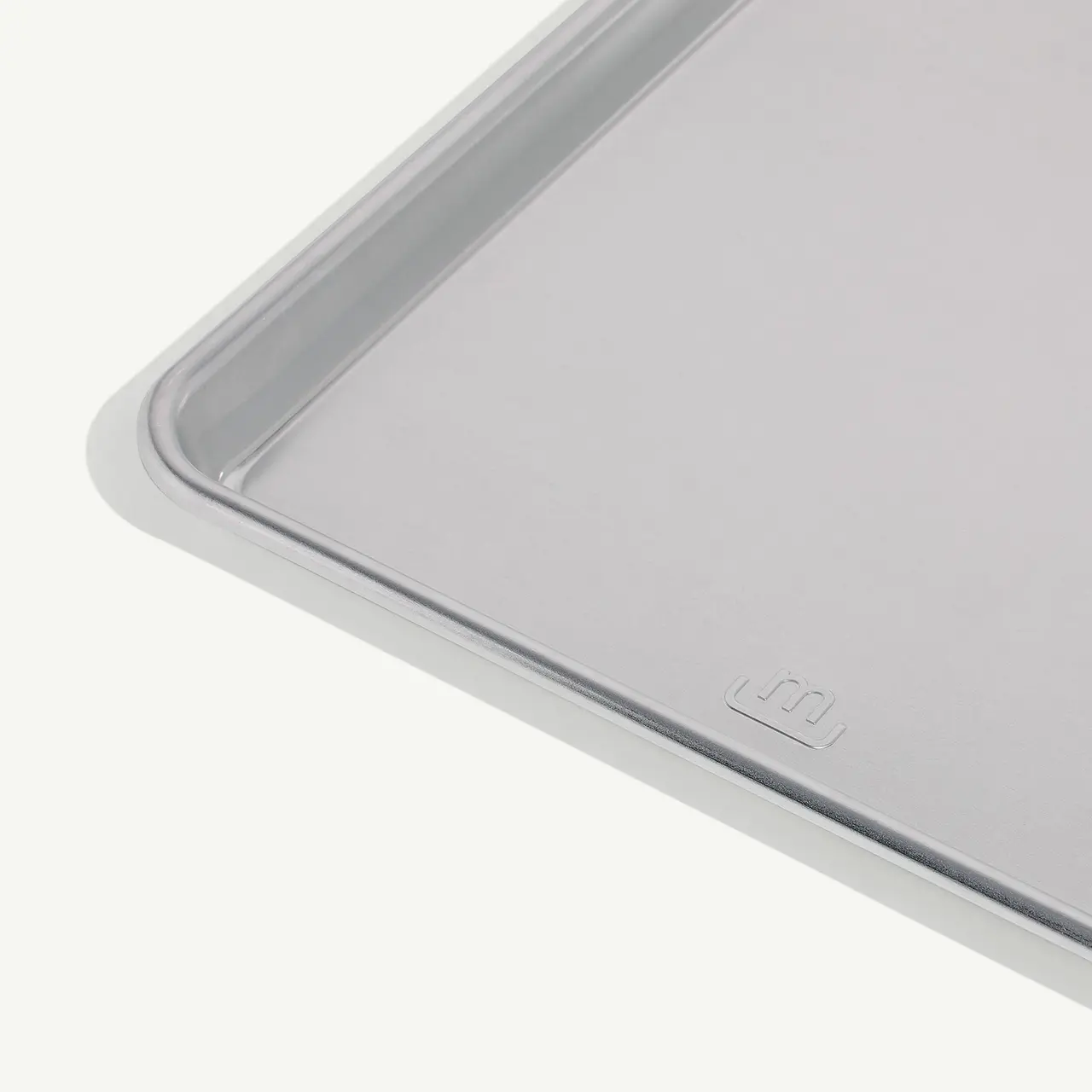 A close-up view of a grey laptop lid corner with an embossed logo.