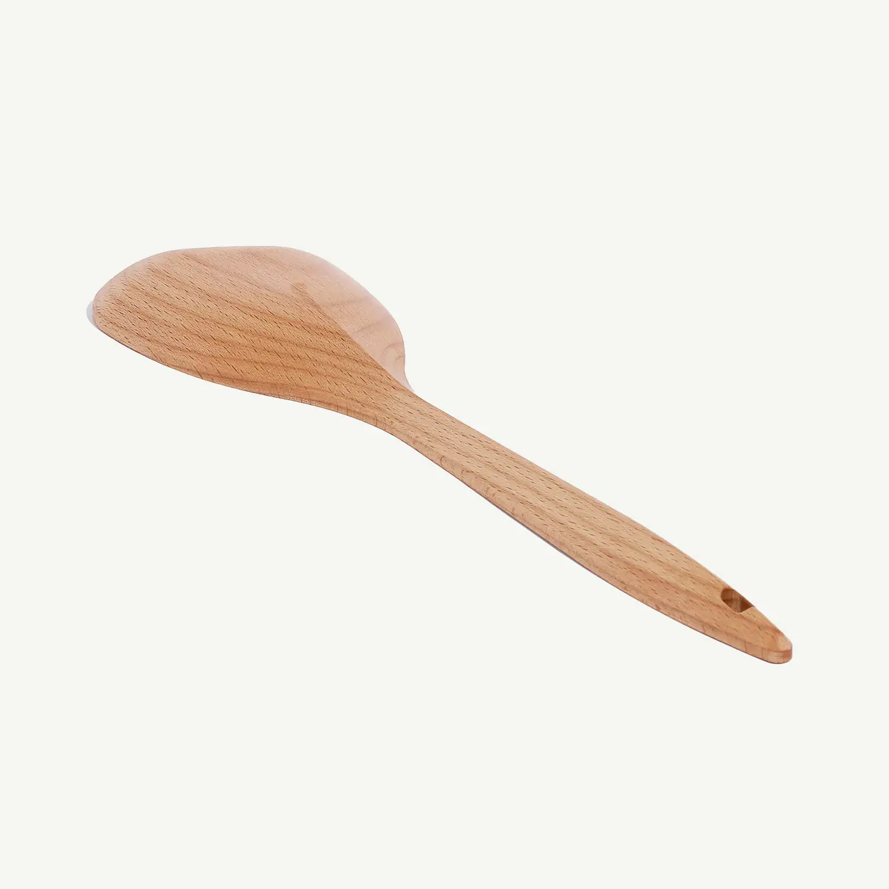 A wooden spoon is isolated against a plain white background.