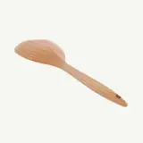 A wooden spoon is isolated against a plain white background.