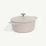 A white dutch oven pot with a lid on a plain background.