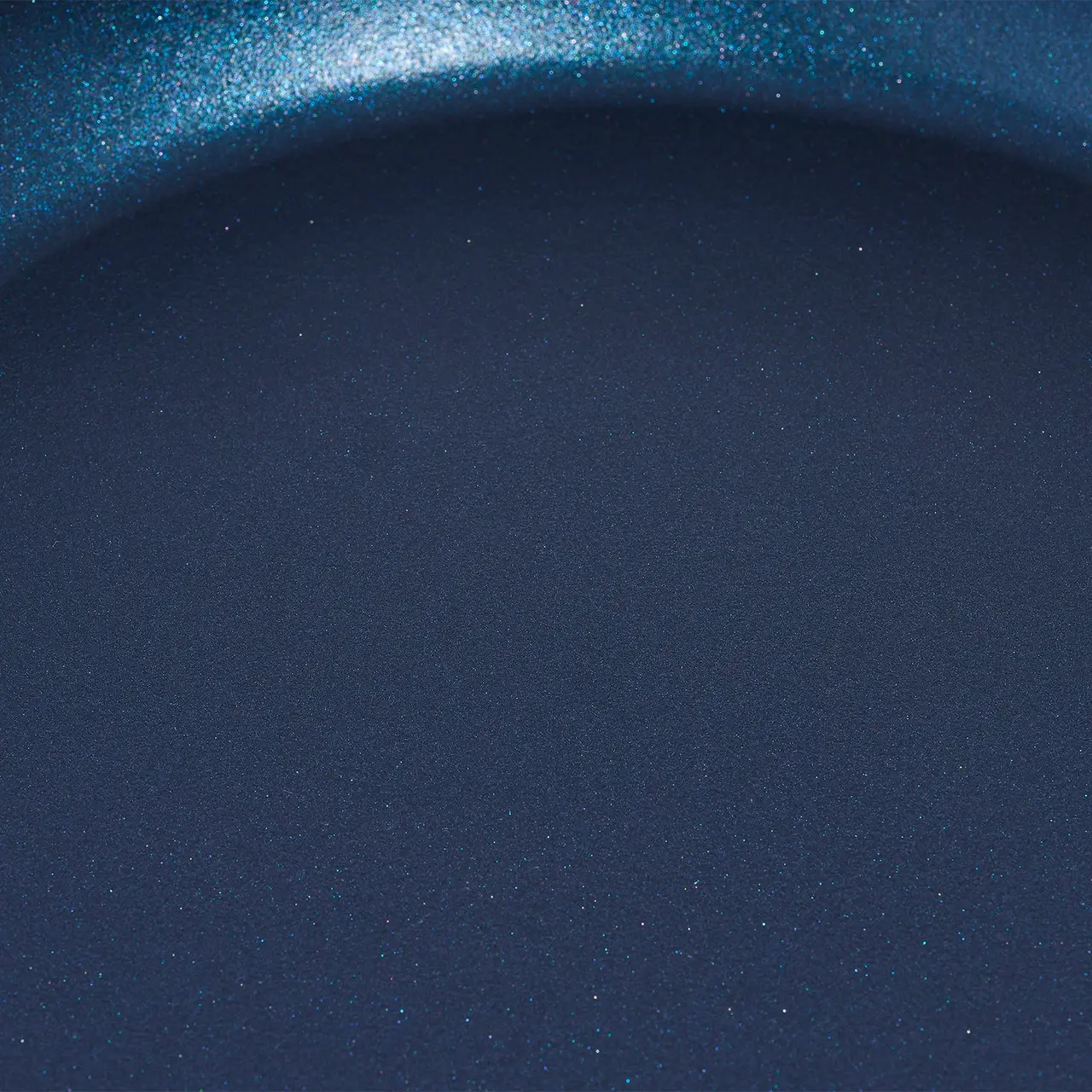 A close-up of a blue object with a smooth texture and subtle sparkle, resembling either a polished stone or a piece of colored glass.