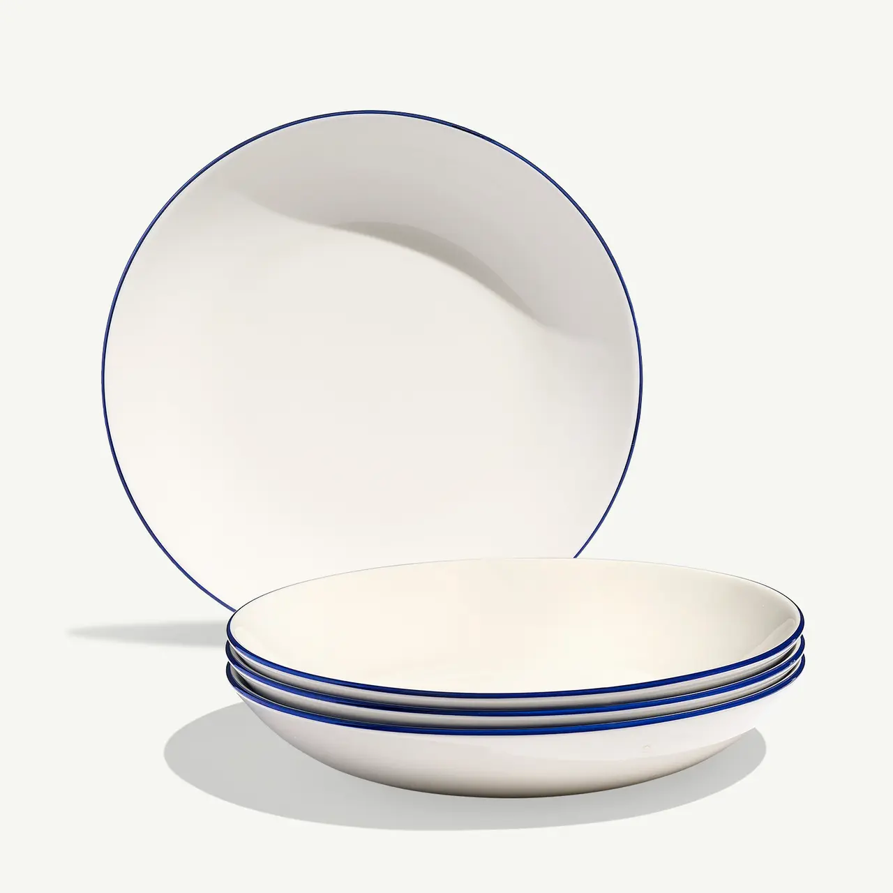 A stack of simple white plates with blue trim lines is displayed against a light background.