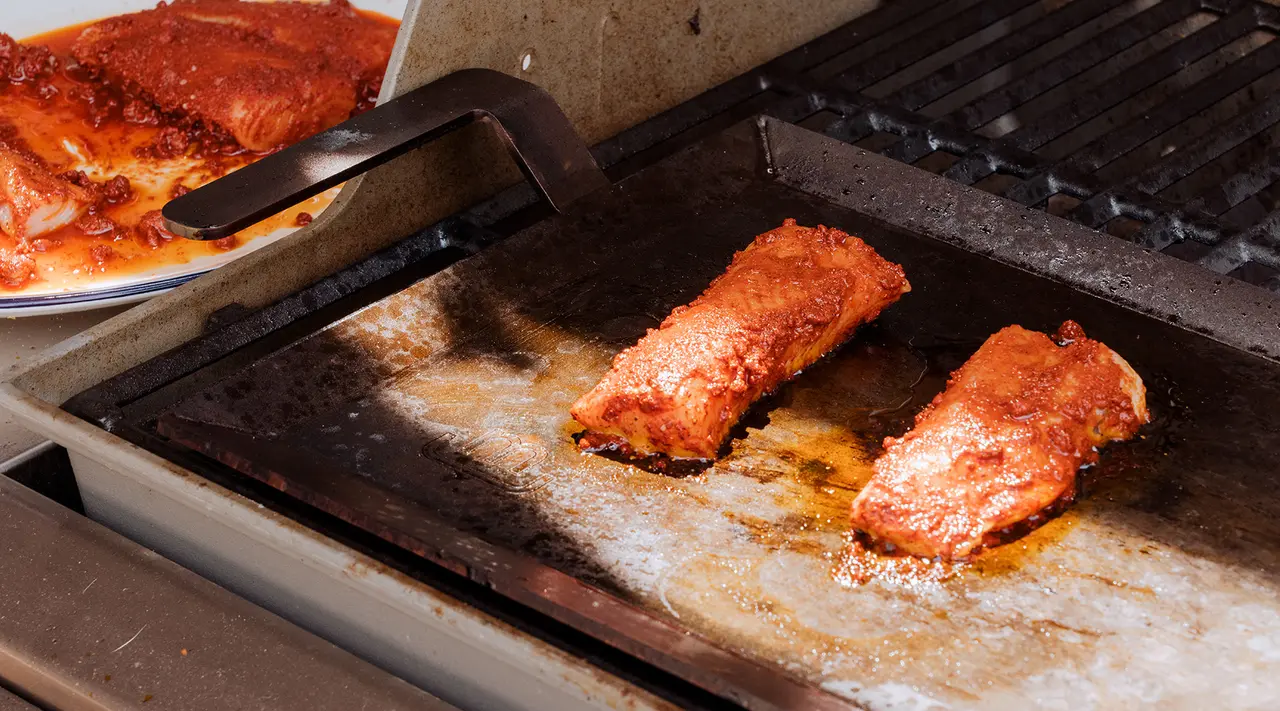 Succulent ribs are being cooked to perfection on a barbecue grill.