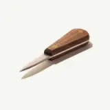 A wooden-handled knife with a sleek blade and minimalistic design rests on a neutral background.