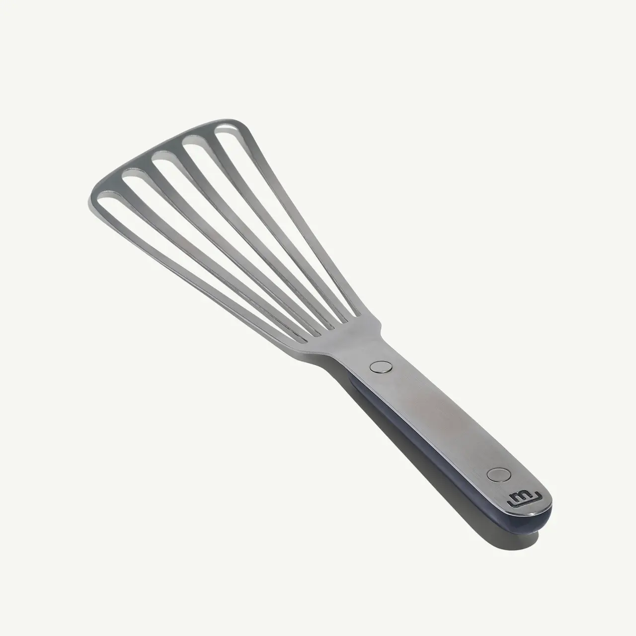 A gray silicone spatula with a metal handle is displayed against a solid background.