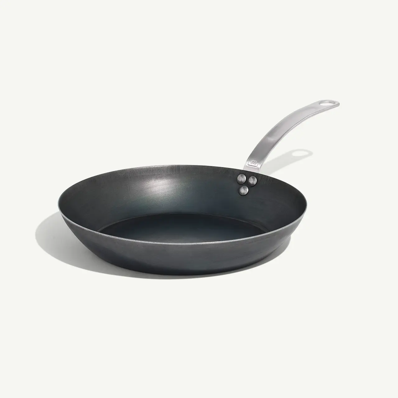 A non-stick frying pan with a stainless steel handle is placed on a light background.