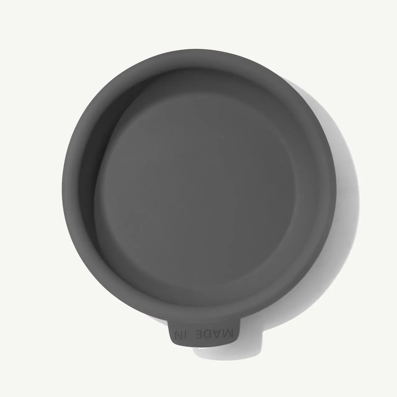 A plain grey coffee cup lid is viewed from directly above.