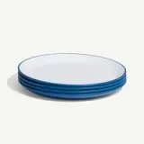 A stack of four white plates with blue rims on a white background.