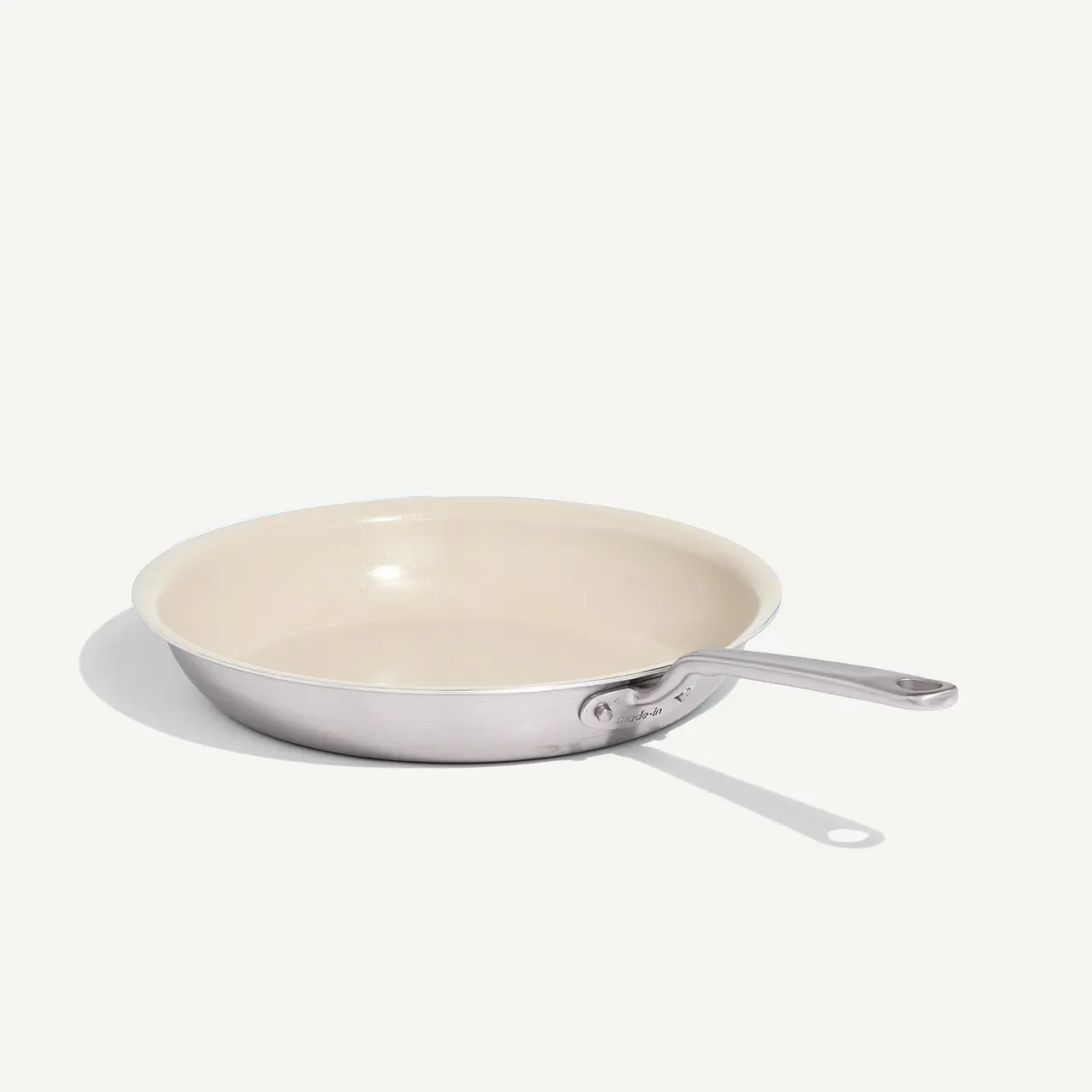 A single stainless steel frying pan with a beige interior is shown on a light background.