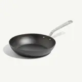 A black non-stick frying pan with a stainless steel handle is displayed against a light background.