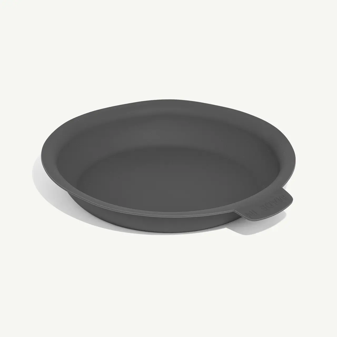 A simplistic gray ceramic plate rests on a neutral background.