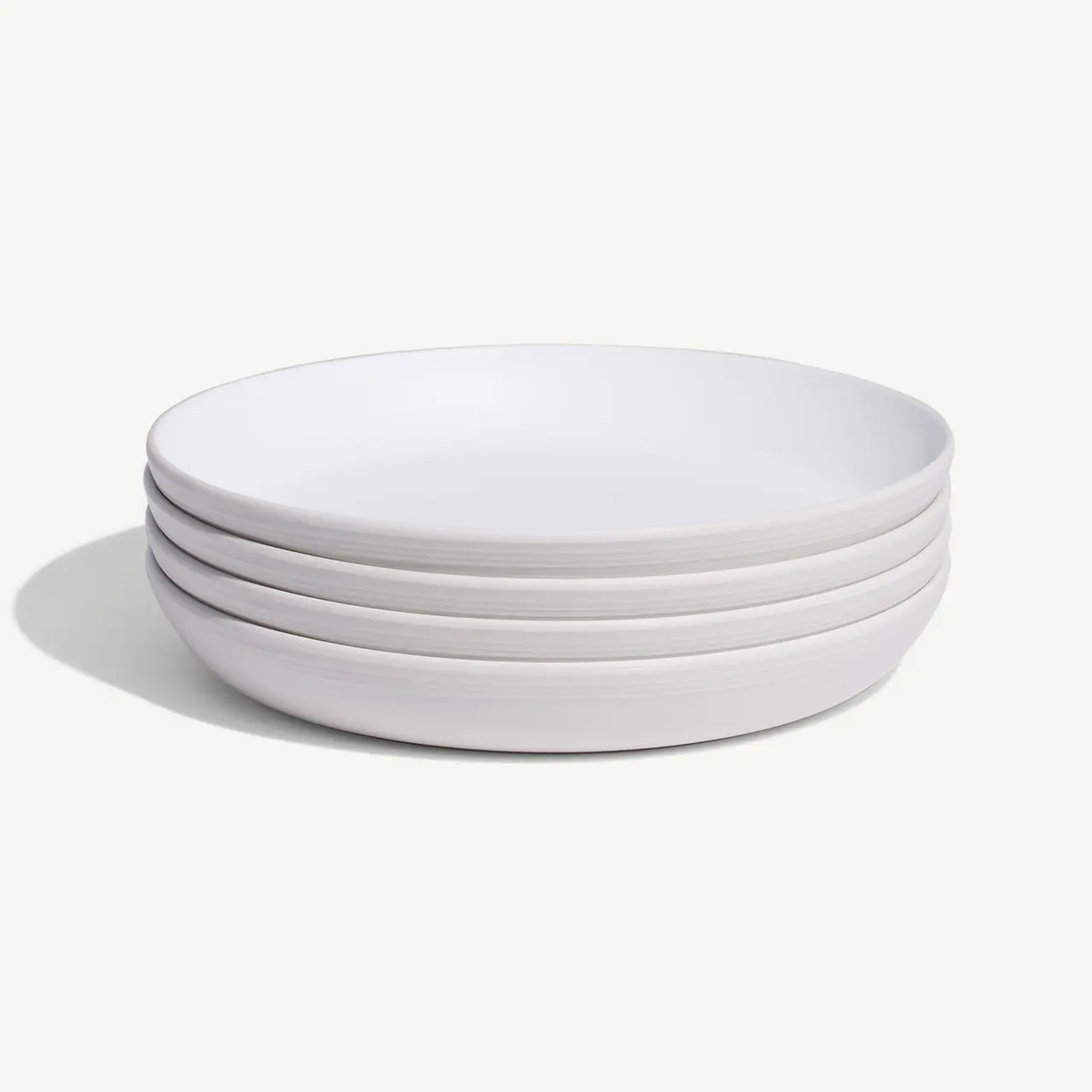A stack of five simple white plates is displayed against a plain background.