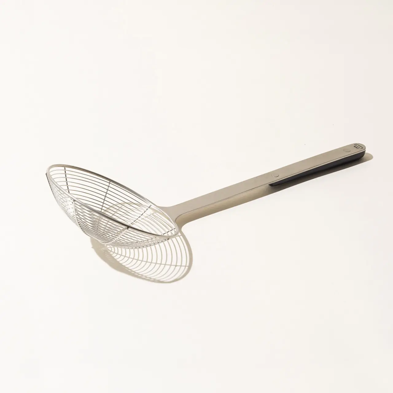 A stainless steel mesh strainer with a long handle isolated on a white background.