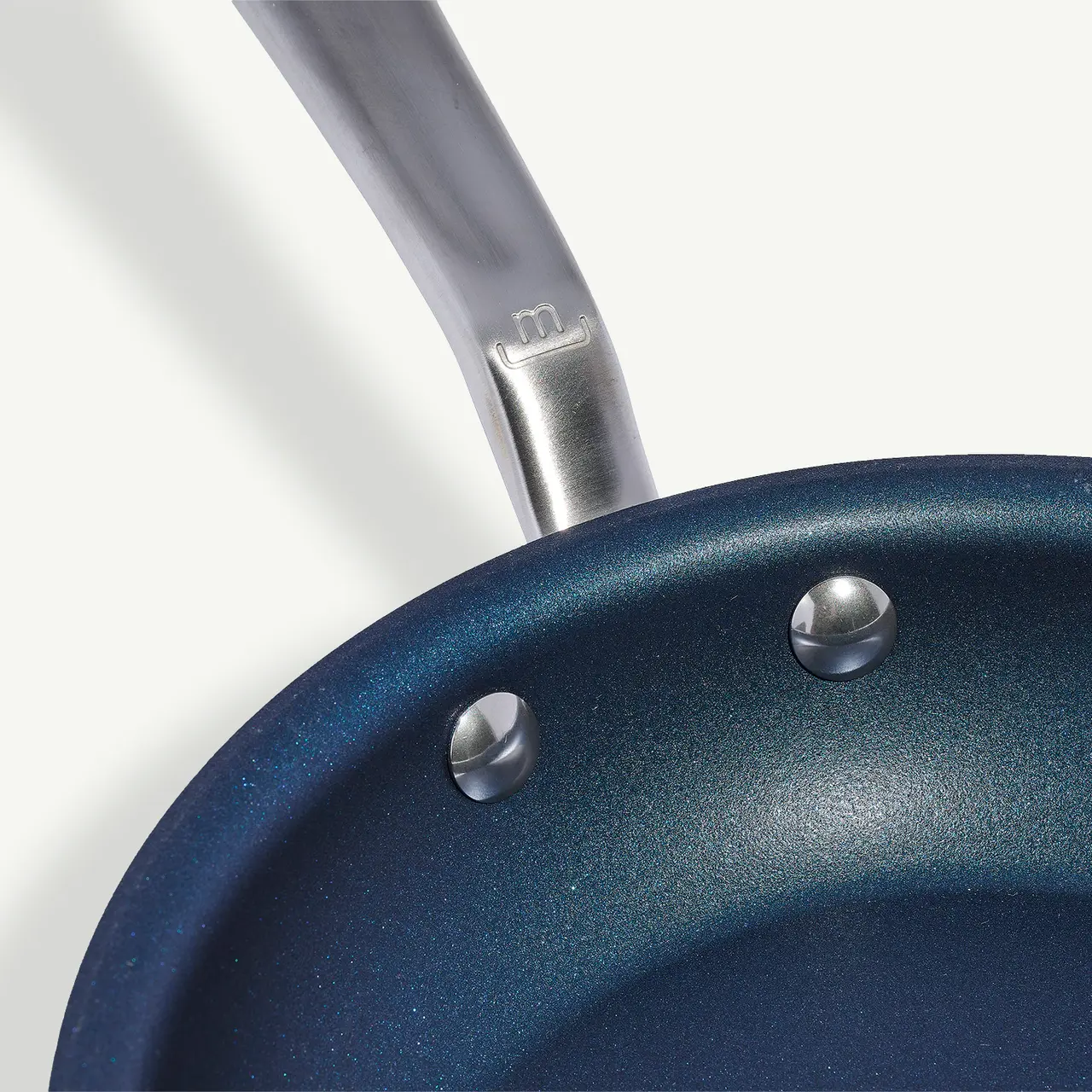 Close-up view of a blue non-stick frying pan with a metallic handle.