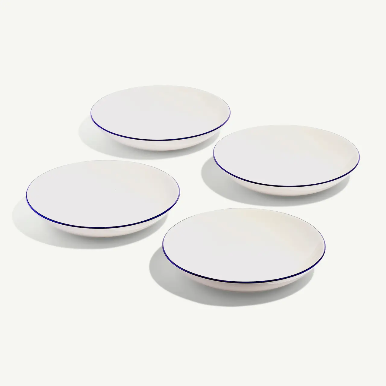 Three white plates with blue rims are arranged on a light background.