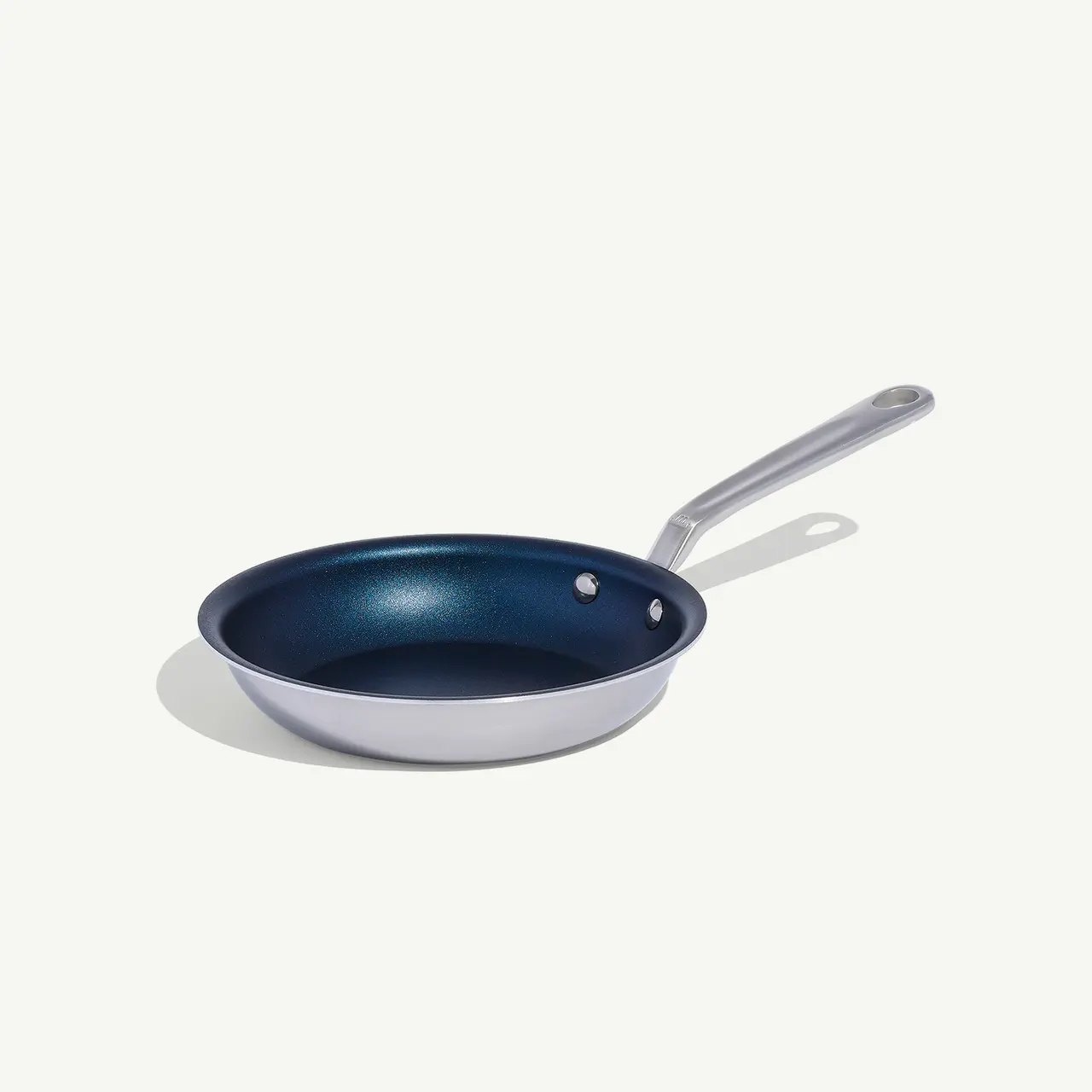 A non-stick frying pan with a silver handle is placed against a white background.