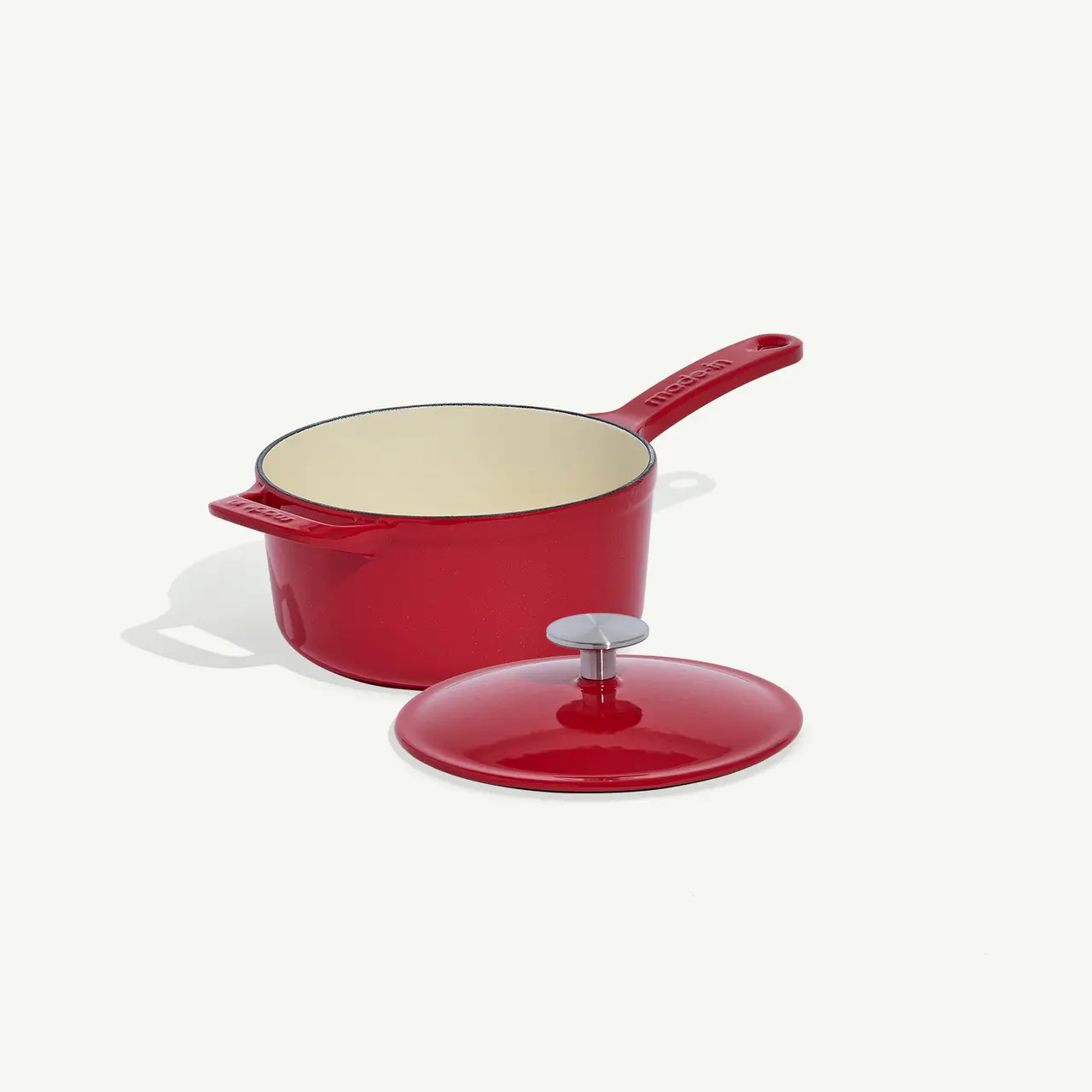 A red saucepan with its lid off is placed on a white background.