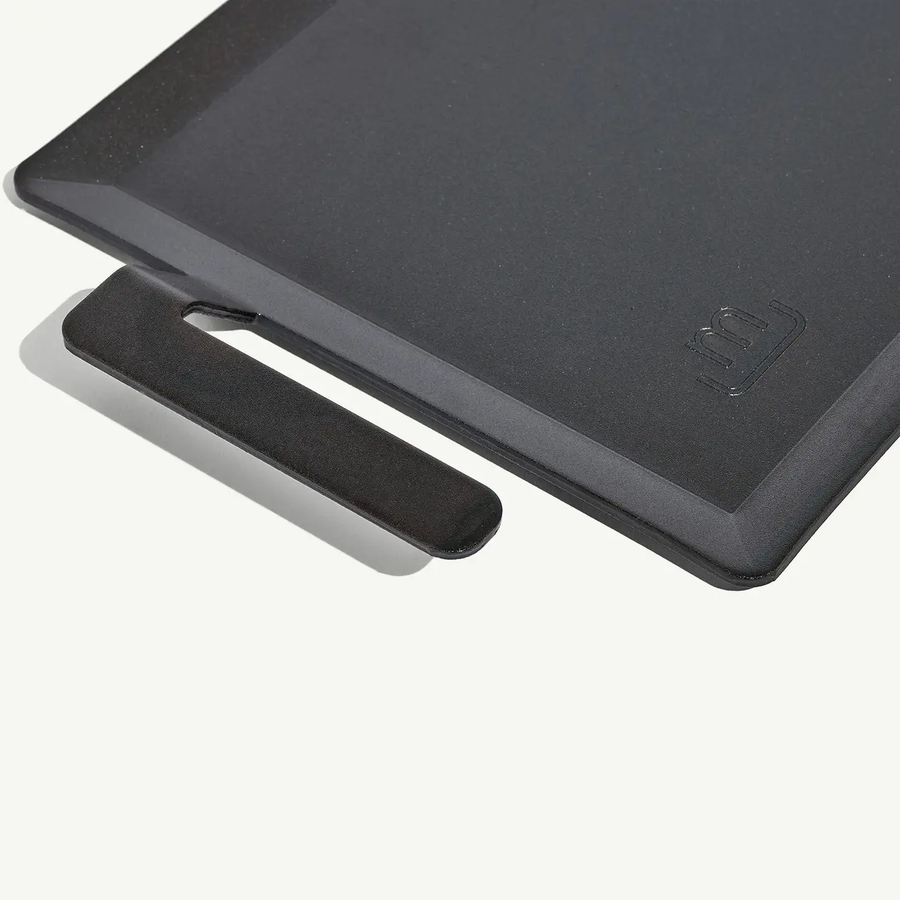 A close-up of a dark-colored laptop lid with a visible brand logo, partially covering a laptop dock or stand.