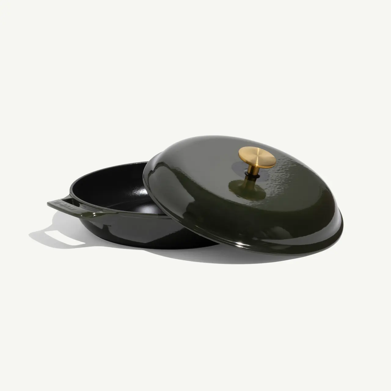 A deep green cooking pot with a matching lid featuring a brass knob and one side handle.