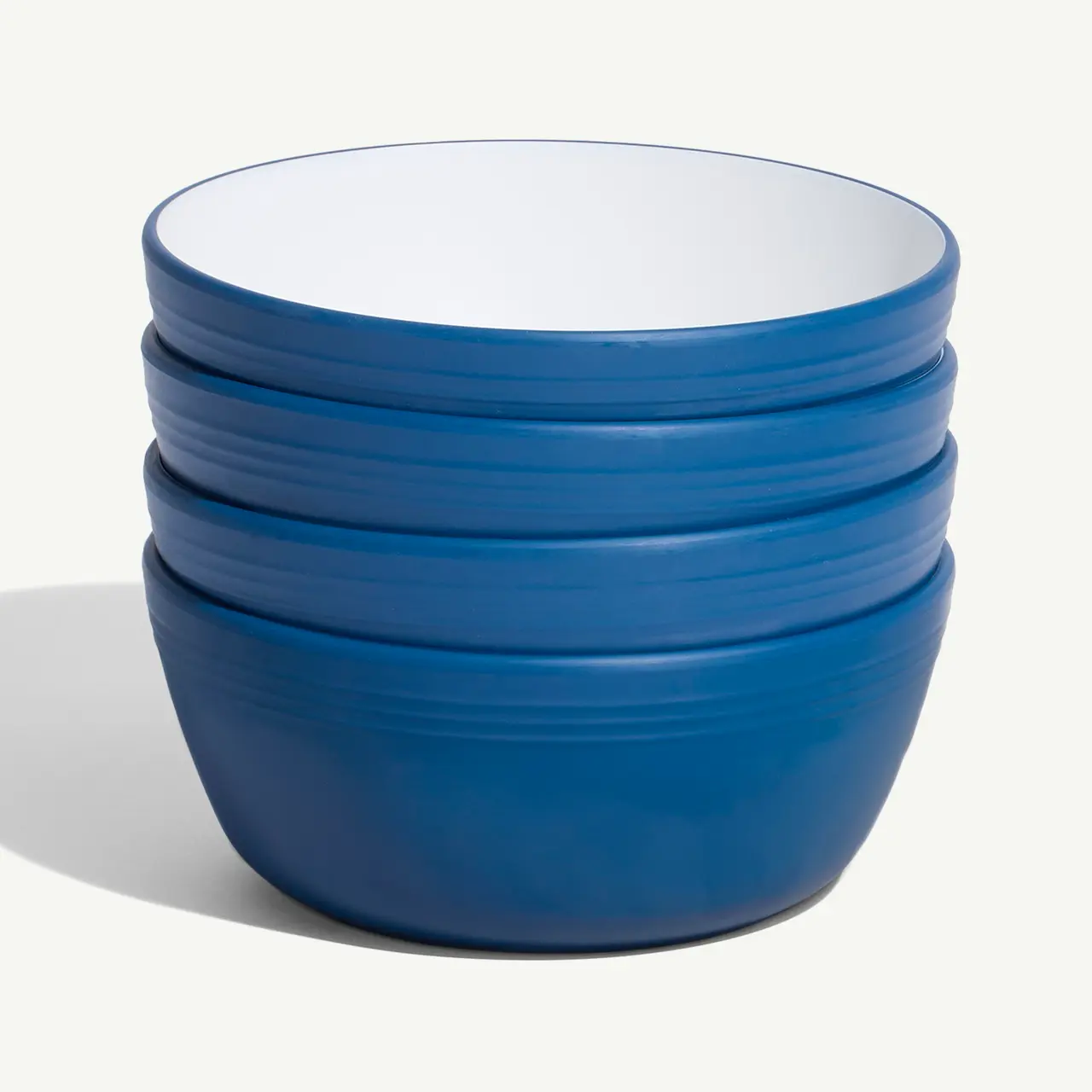 A stack of blue ceramic bowls on a plain background.