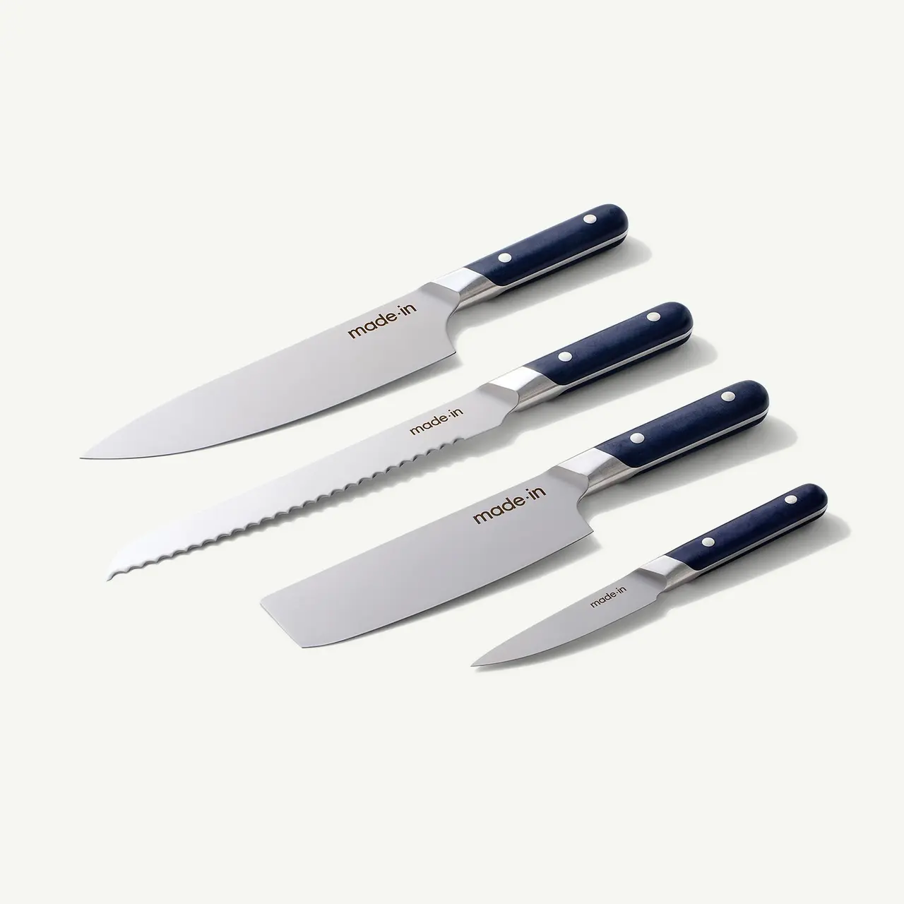 Five assorted kitchen knives with navy blue handles are neatly arranged on a light background.