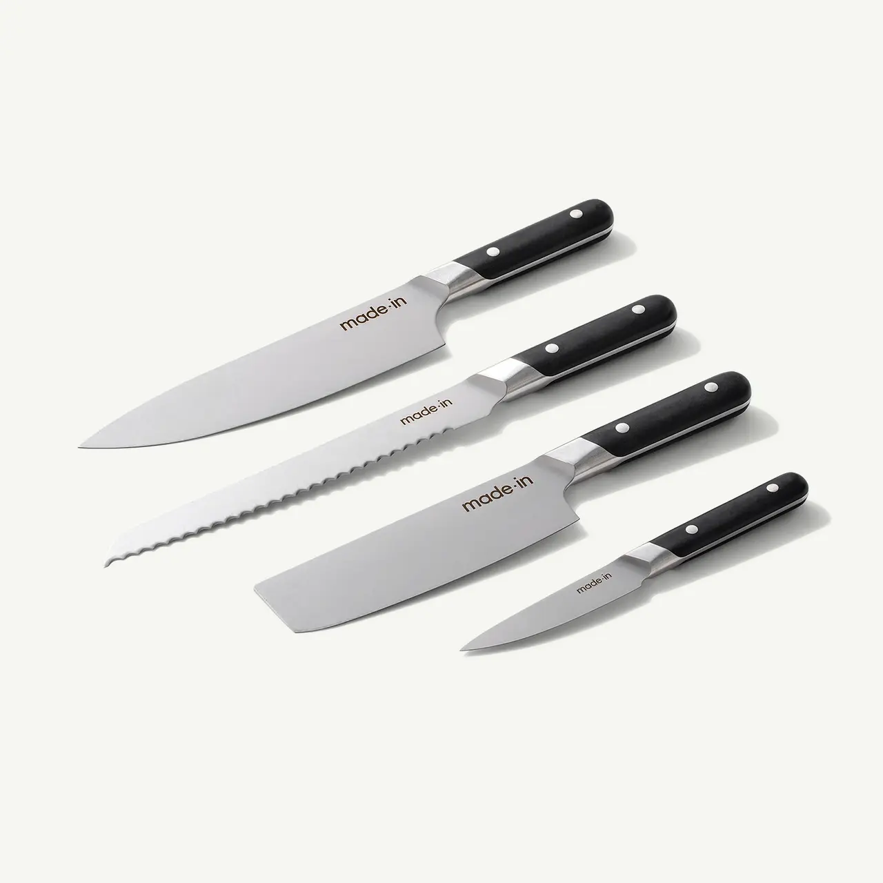 A collection of five kitchen knives with black handles, each displaying different blade designs, arranged neatly on a light background.
